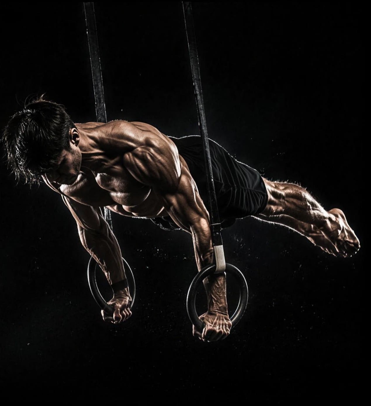 Calisthenics athlete holding a full planche on gymnastic rings